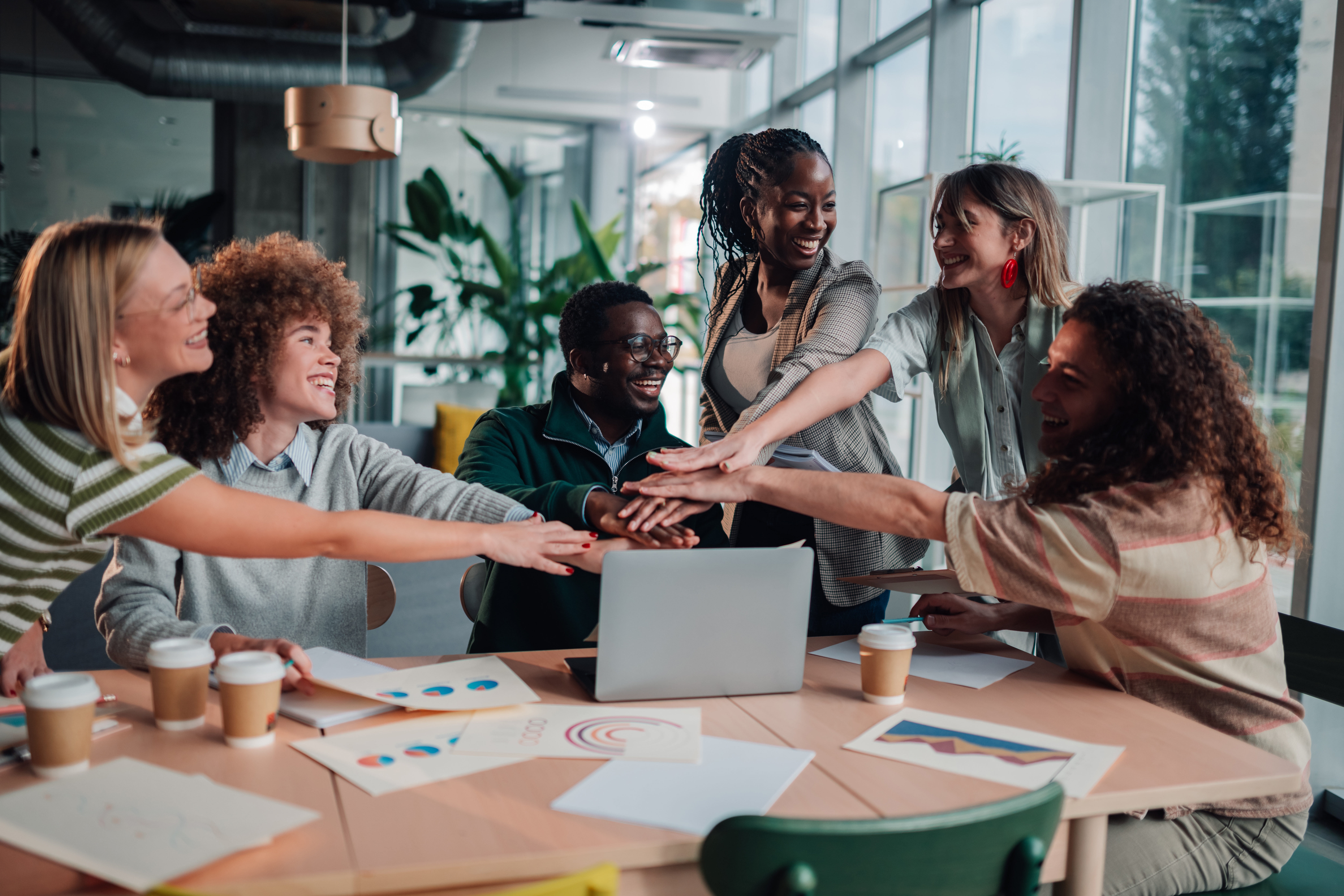 Happy Business Team Members Stacking Hands Together In A Modern
